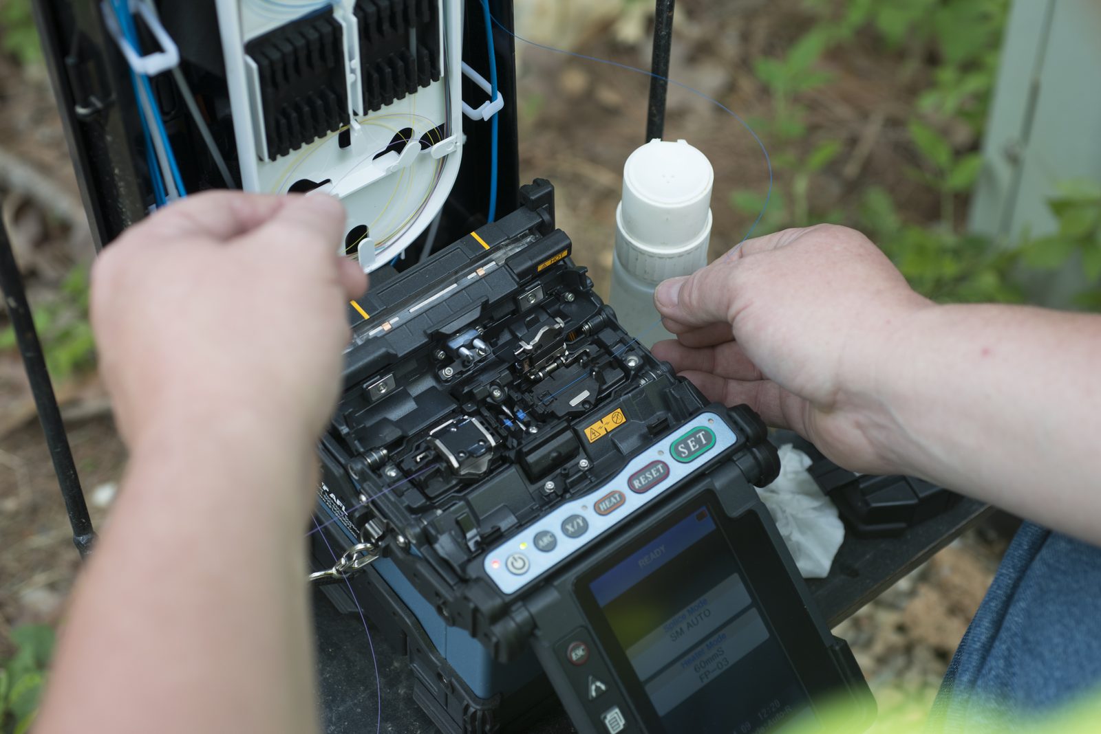 Technician fusion splicing fiber in the field — Titan Networks Fiber